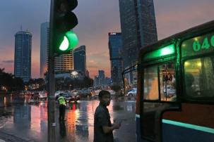(Dita Alangkara/AP) A conductor waits near his bus as a police officer halts the traffic to clear jams during rush hour at the main business district in Jakarta, Indonesia, Friday, Nov. 29, 2013. Jakarta, a megacity with over 9 million inhabitants, is known to have one of the worst traffic jams in Asia. (AP Photo/Dita Alangkara)